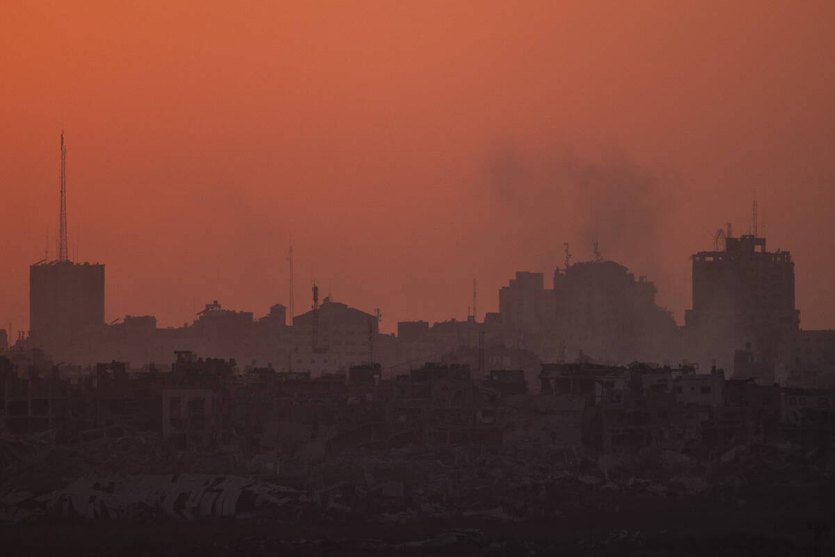 Destroyed buildings stand in the Gaza Strip during the sunset as seen from southern Israel, Wed ...