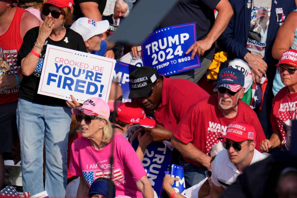 Members of the crowd react as U.S. Secret Service agents surround Republican presidential candi ...