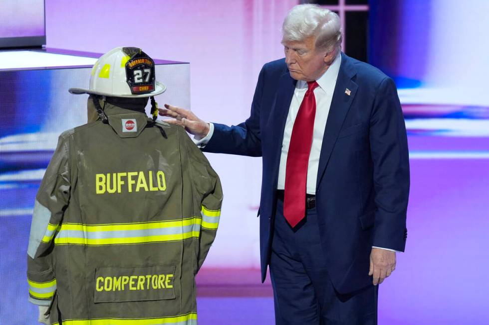 Republican presidential candidate former President Donald Trump standing next to the uniform of ...