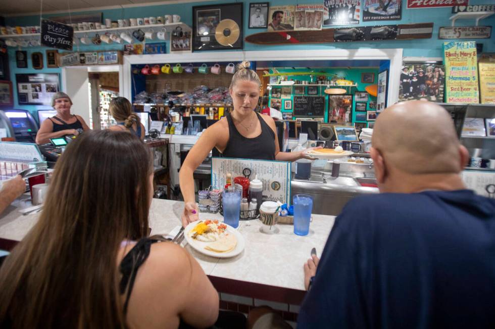 Server Emmy Howe, center, runs food out to customers, Friday, July 19, 2024, in Boulder City. ( ...