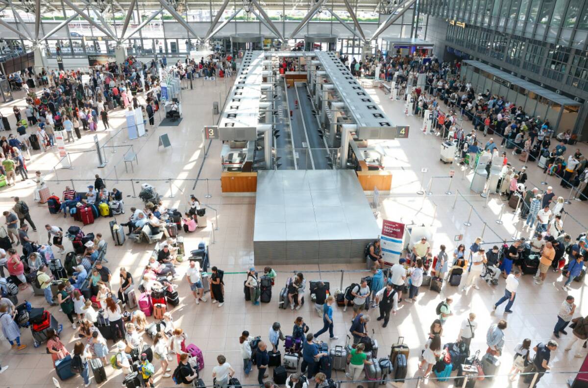 Travelers wait in Terminal 1 for check-in at Hamburg Airport, in Hamburg, Germany, Friday July ...