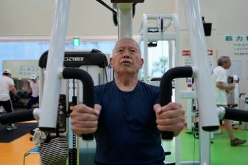 Shigeo Takahashi, 83, uses a pec deck machine as he works out at the Fukagawa Sports Center in ...