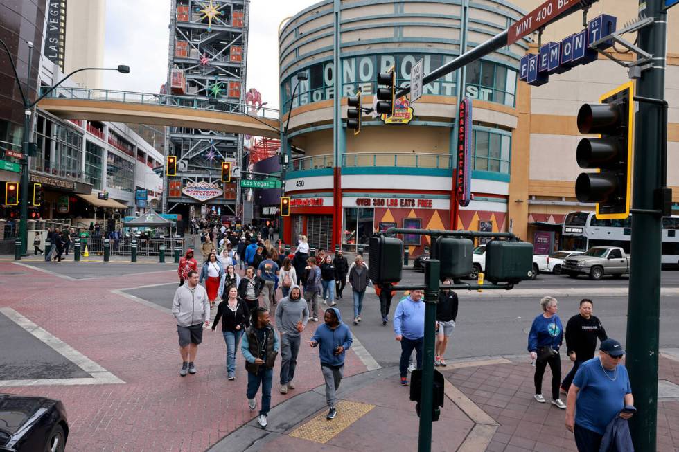 Pedestrians cross Las Vegas Boulevard at Fremont street in downtown Las Vegas Friday, March 15, ...