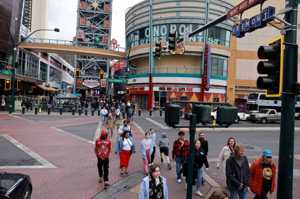 Pedestrians cross Las Vegas Boulevard at Fremont street in downtown Las Vegas Friday, March 15, ...