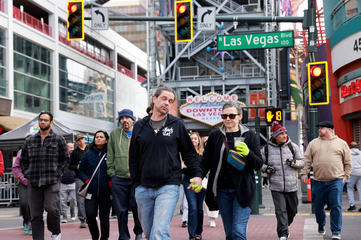 Pedestrians cross Las Vegas Boulevard at Fremont street in downtown Las Vegas Friday, March 15, ...