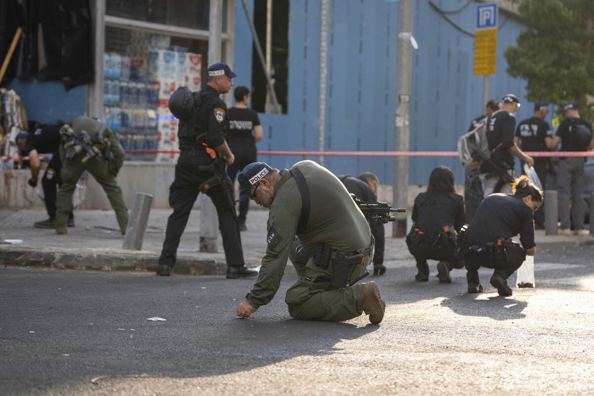 Israeli police investigate the scene of an explosive drone attack in Tel Aviv, Israel, Friday, ...