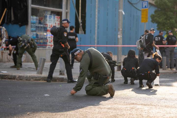 Israeli police investigate the scene of an explosive drone attack in Tel Aviv, Israel, Friday, ...