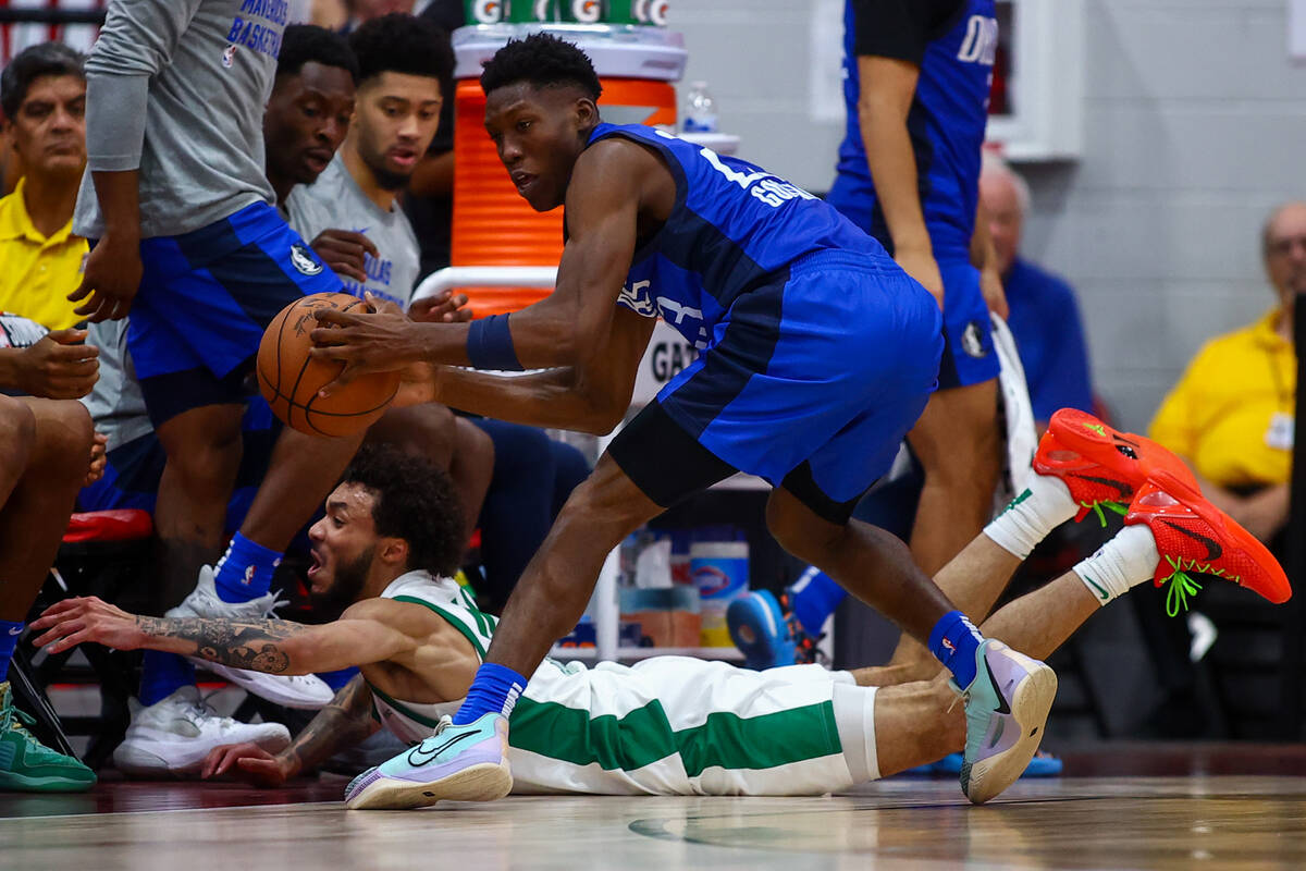 Boston Celtics forward Anton Watson dives for a loose ball while Dallas Mavericks guard Jazian ...