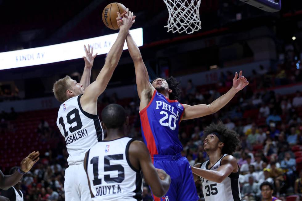 Philadelphia 76ers guard Jared McCain (20) and San Antonio Spurs forward Yauhen Massalski (19) ...