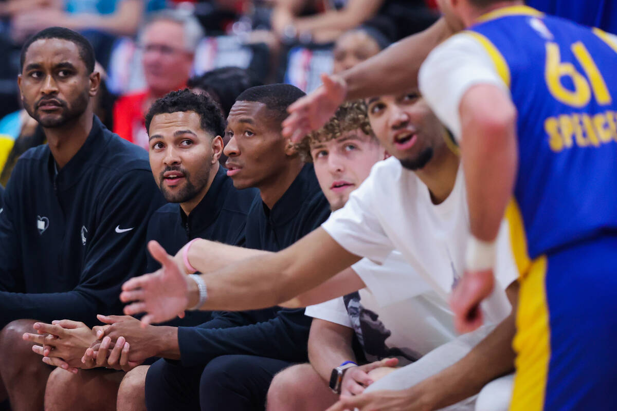 Golden State Warriors assistant coach Noah Robotham, second from left, watches game action from ...