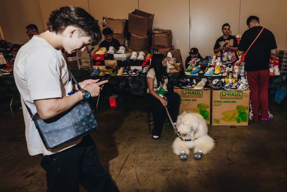 An attendee walks by booths selling clothes and shoes during Sneaker Con at the Mandalay Bay Co ...