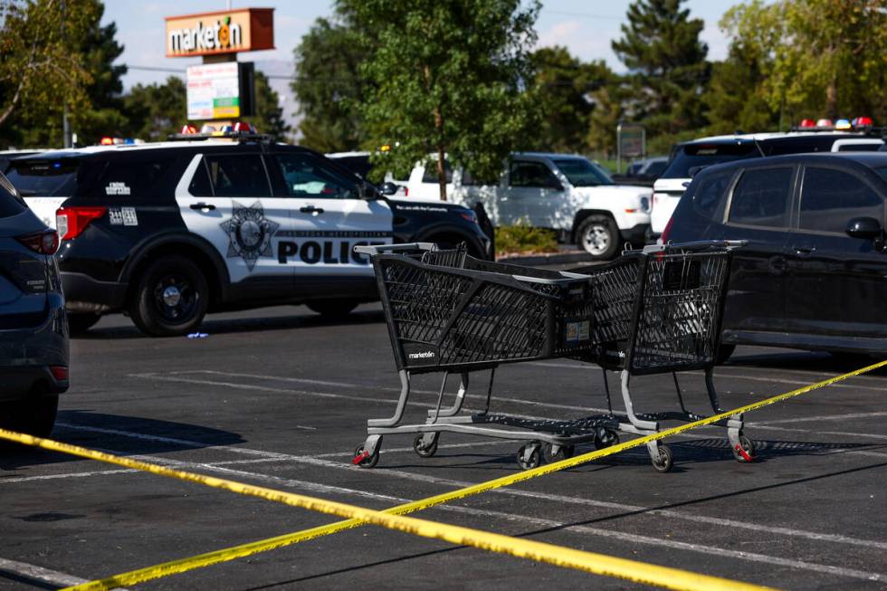 Metropolitan Police Department officers investigate a taped-off scene at a shopping center park ...