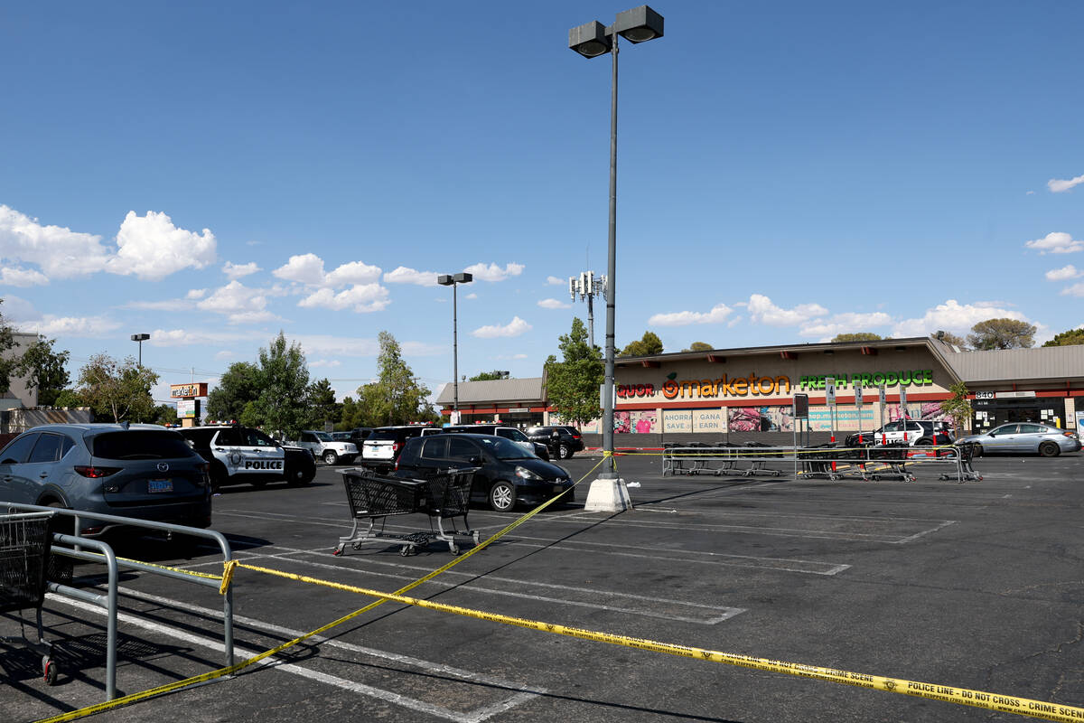 Metropolitan Police Department officers investigate a taped-off scene at a shopping center park ...