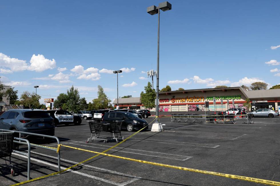 Metropolitan Police Department officers investigate a taped-off scene at a shopping center park ...