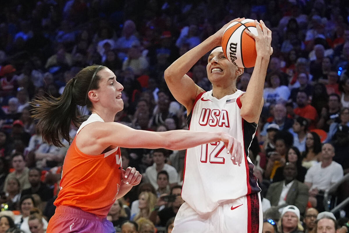 Diana Taurasi (12), of Team USA, is fouled by Caitlin Clark, left, of Team WNBA, during the fir ...