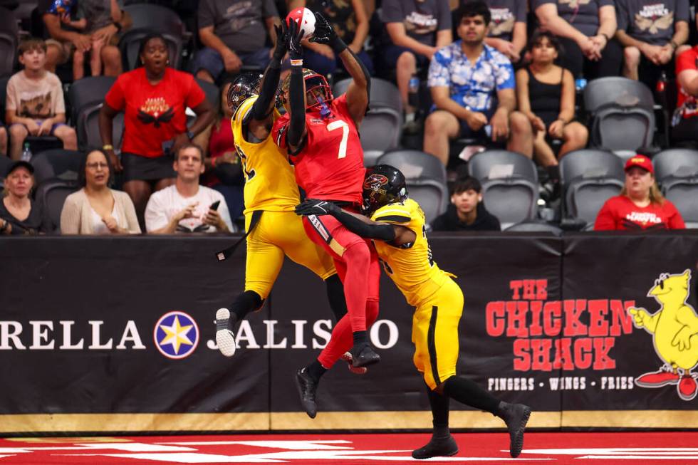 Vegas Knight Hawks wide receiver CJ Windham (7) catches a touchdown pass with pressure from Tuc ...