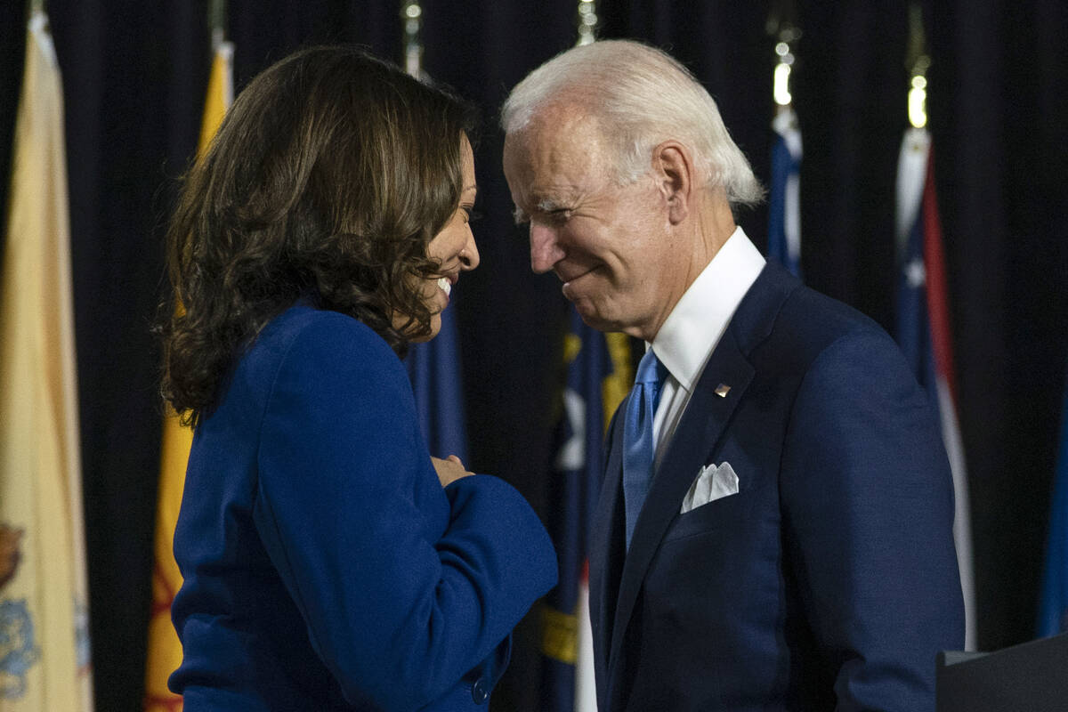 Joe Biden and his running mate Sen. Kamala Harris, D-Calif., pass each other as Harris moves to ...