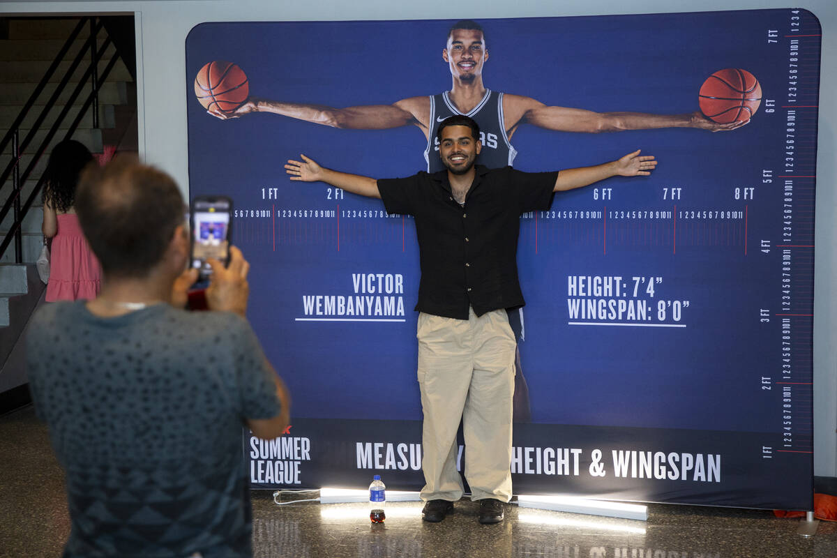 Fans compare their height and wingspan to San Antonio Spurs center Victor Wembanyama before the ...
