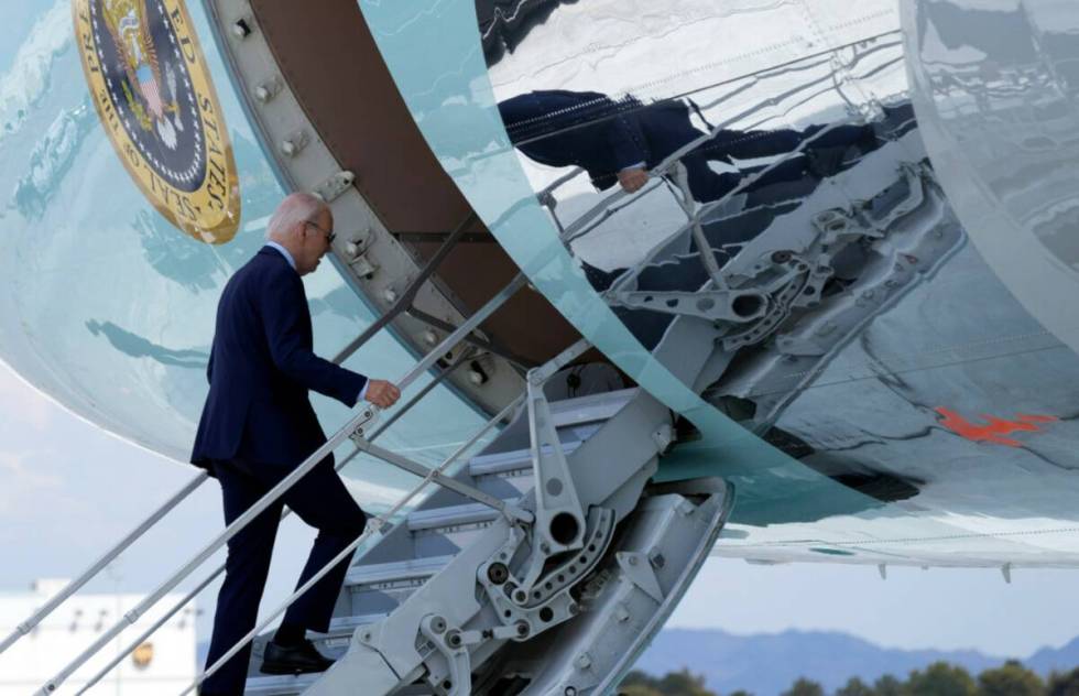 President Joe Biden walks up the steps of Air Force One at Harry Reid International Airport in ...