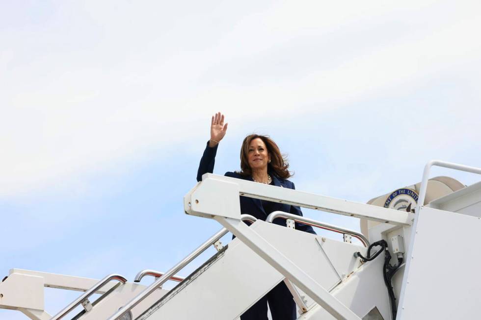 Vice President Kamala Harris waves while boarding Air Force Two as she departs on campaign trav ...