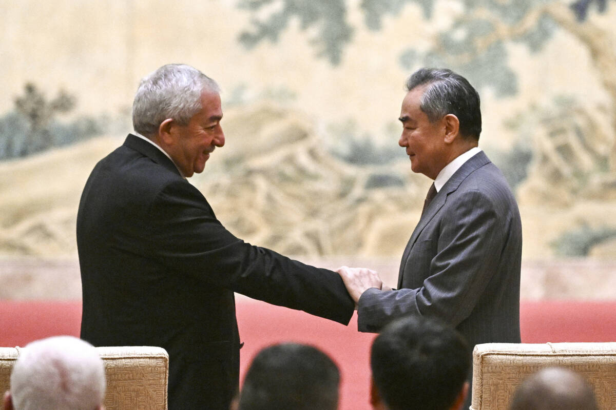 Mahmoud al-Aloul, left, vice chairman of Fatah, shakes hands with China's Foreign Minister Wang ...