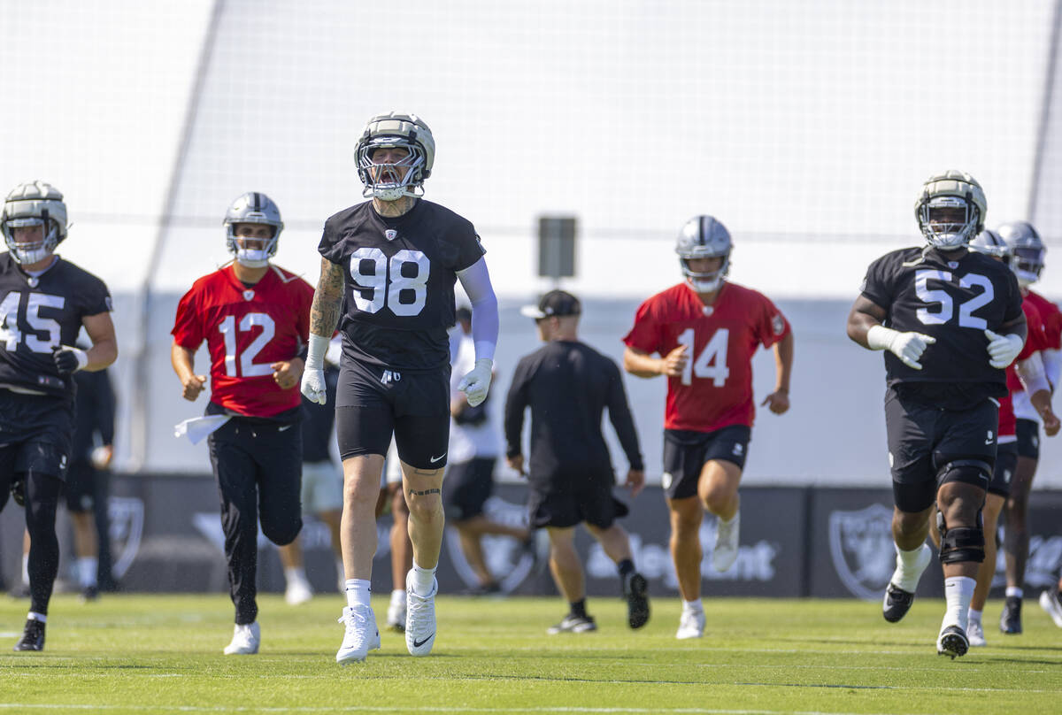 Raiders defensive end Max Crosby (98) yells as he and the team warm up during the first day of ...