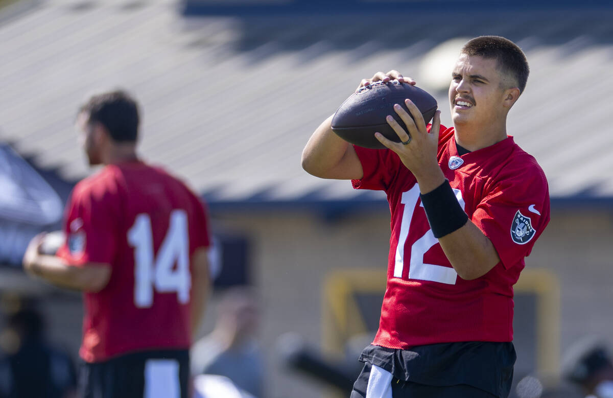 Raiders quarterback Aidan O'Connell (12) catches the ball during the first day of training camp ...