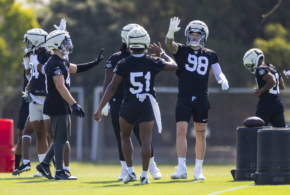 Raiders defensive end Maxx Crosby (98) greets defensive end Malcolm Koonce (51) during the firs ...