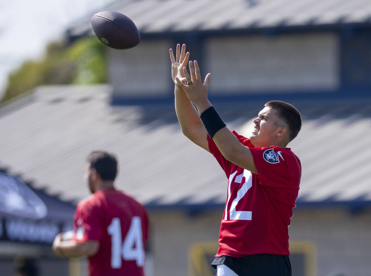 Raiders quarterback Aidan O'Connell (12) catches the ball during the first day of training camp ...