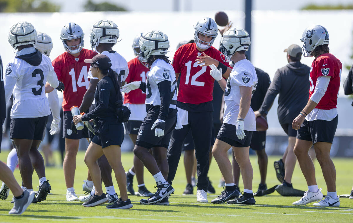 Raiders quarterback Aidan O'Connell (12) greet teammates during the first day of training camp ...