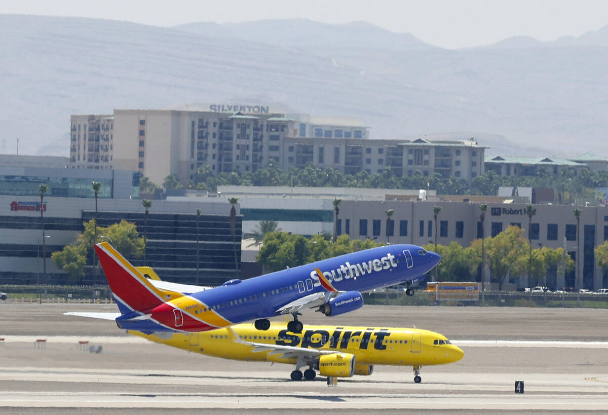 A Southwest Airlines jet takes off as a Spirit Airlines jet taxis at Harry Reid International A ...