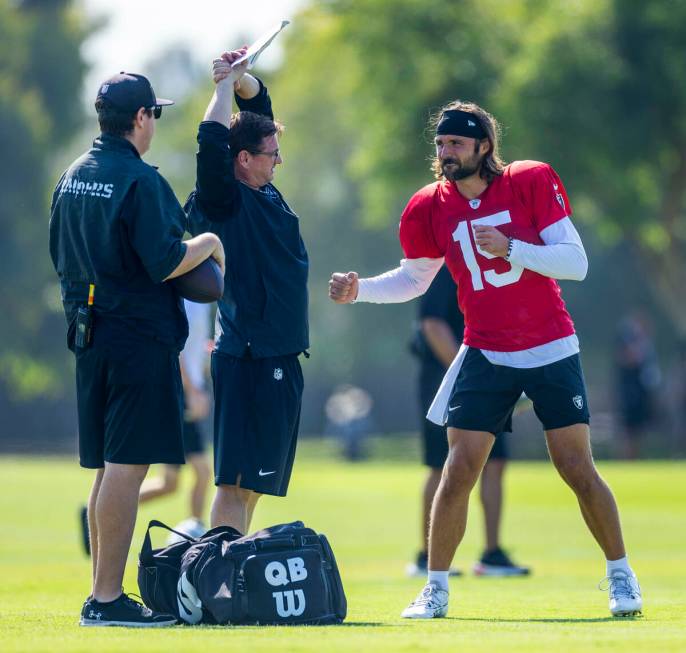 Raiders quarterback Gardner Minshew (15) throws a fake punch while talking with staff during th ...