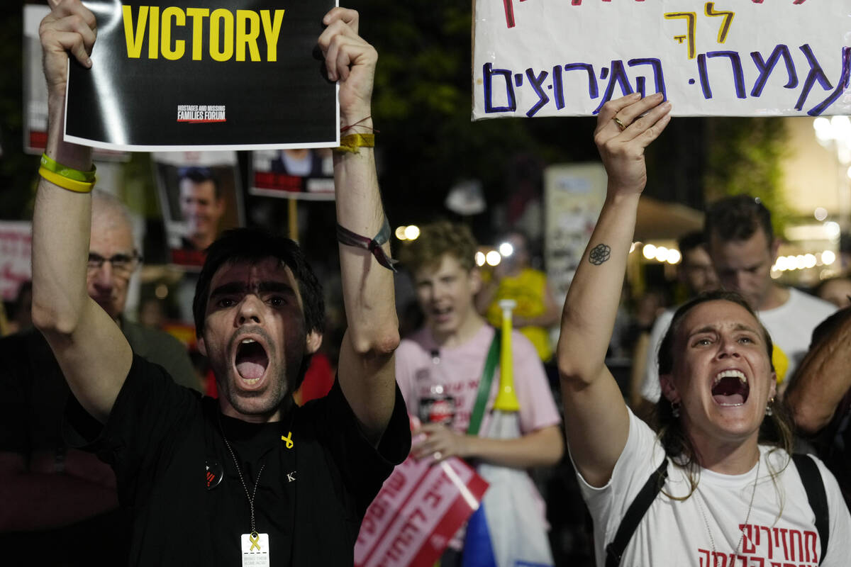 Holding signs with photos of Israeli hostages and demanding their release, people react as they ...