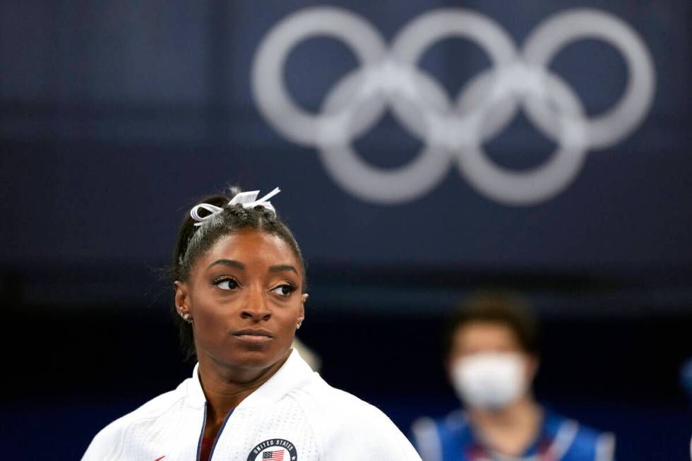 FILE - In this July 27, 2021 file photo, Simone Biles, of the United States, watches gymnasts p ...