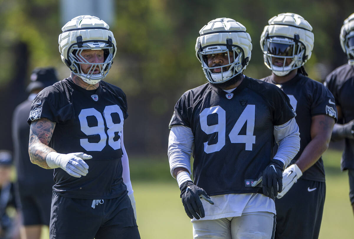 Raiders defensive tackle Christian Wilkins (94) looks to defensive end Maxx Crosby (98) on a dr ...