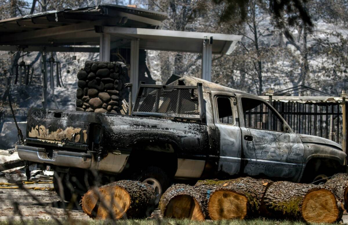 A burnt out vehicle is seen near a home destroyed by the Park Fire in Chico, Calif., Thursday, ...
