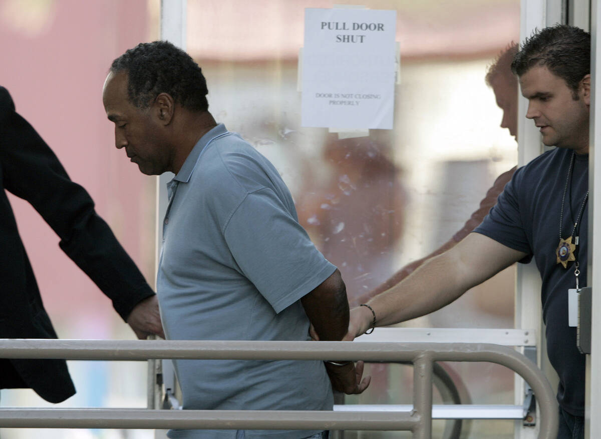 O.J. Simpson is taken from the Las Vegas Police Investigative Services Division in Las Vegas in ...