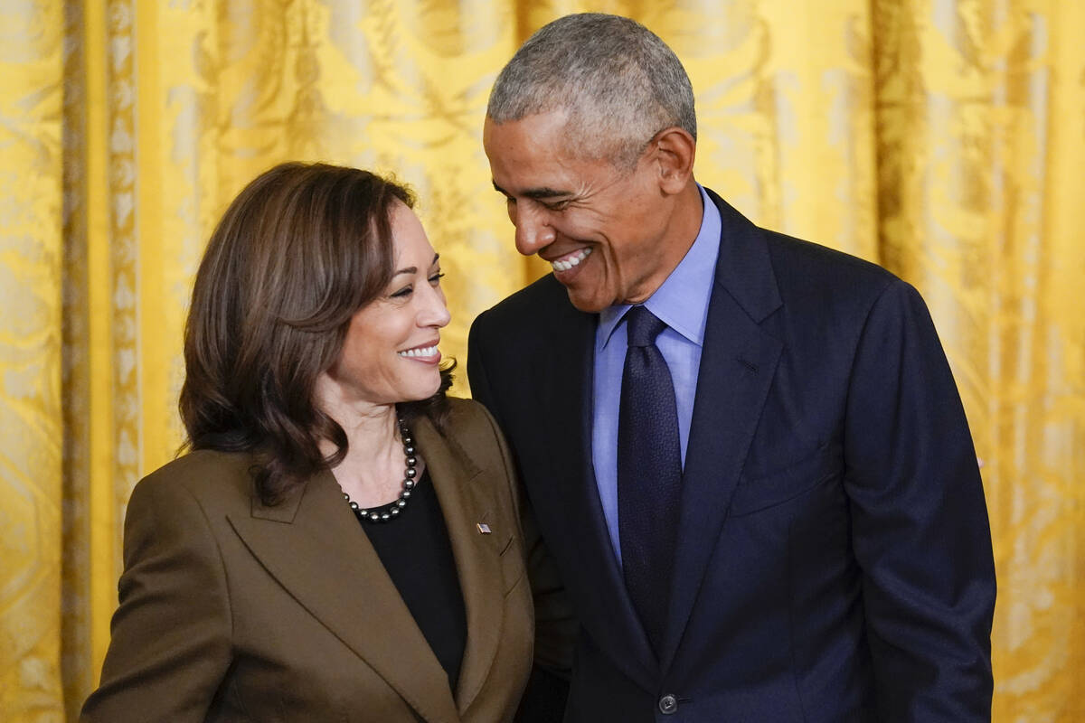 Former President Barack Obama talks with Vice President Kamala Harris during an event about the ...