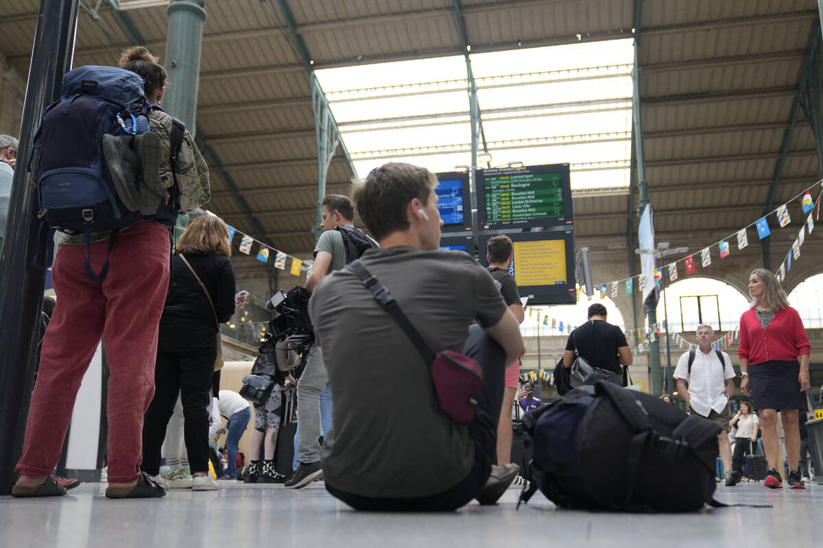 A traveler sits inside the Gare du Nord train station at the 2024 Summer Olympics, Friday, July ...