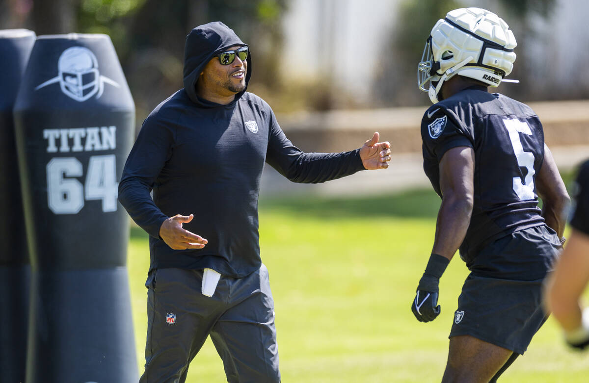 Raiders head coach Antonio Pierce works with linebacker Divine Deablo (5) on a drill during the ...