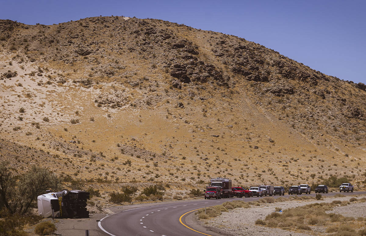 Law enforcement agencies vehicles are seen gathered by the scene of an overturned truck fire ca ...