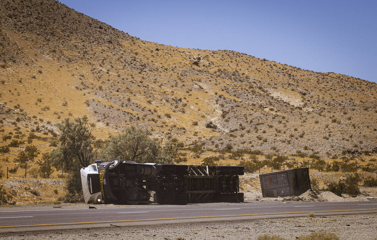 Law enforcement agencies vehicles are seen gathered by the scene of an overturned truck fire ca ...