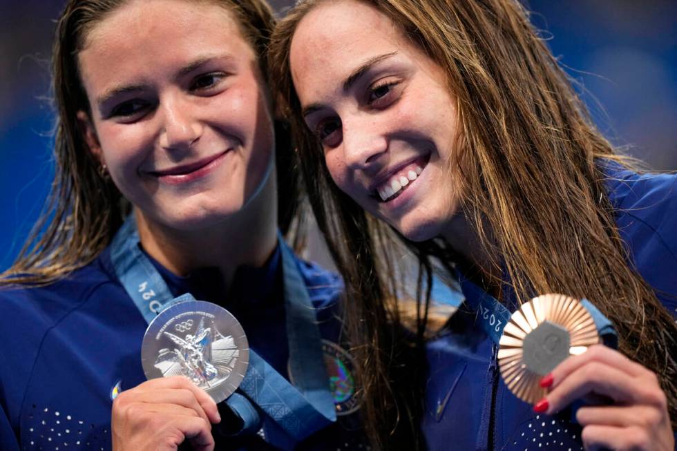 Silver medalist, Katie Grimes, left, of the United States, left, stands with compatriot and bro ...