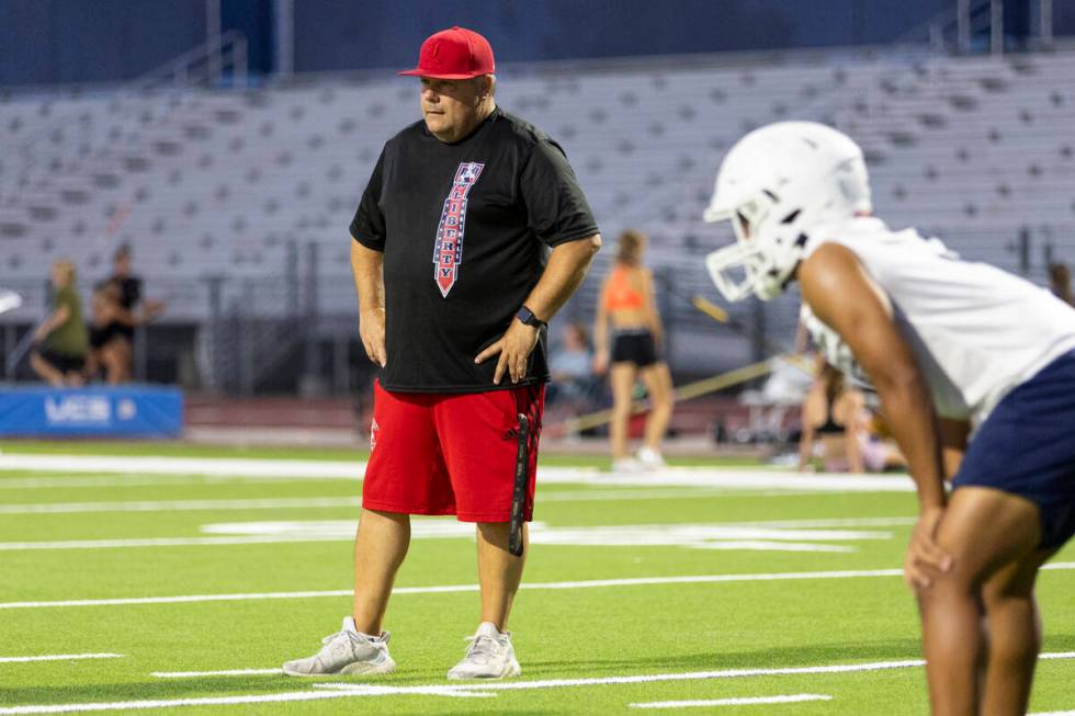 Head coach Rich Muraco watches his players run plays during a team football practice at Liberty ...