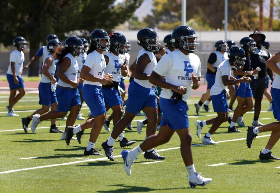 Desert Pines players warm up during the first day of high school football practice, on Monday, ...