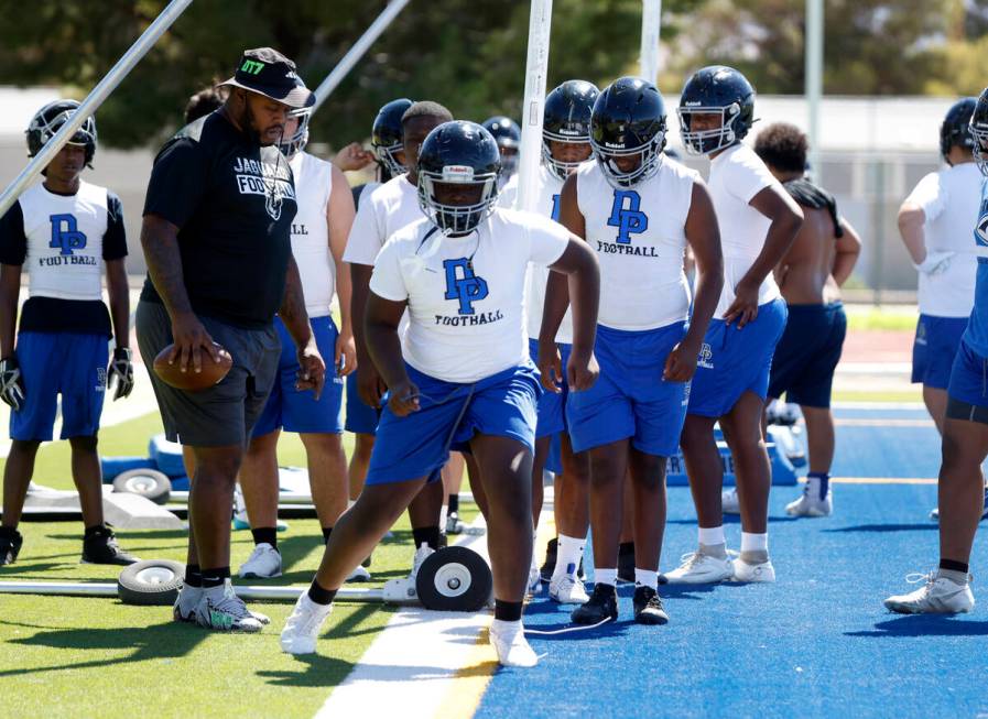 Desert Pines defensive line coach Kenny Mack, left, watches as players, including defensive lin ...