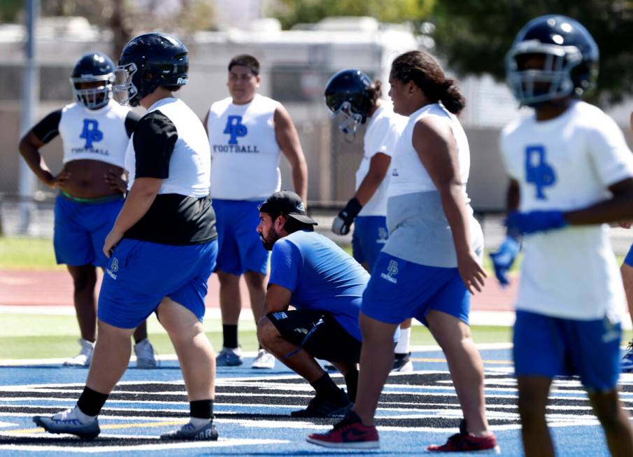 Desert Pines head coach Jose Flores, center, watches as players take the field to participate i ...