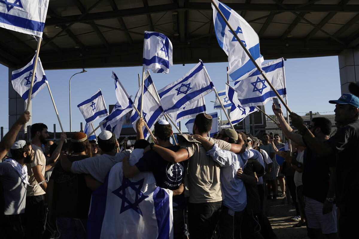 Protesters wave Israeli national flags in support of soldiers being questioned for detainee abu ...