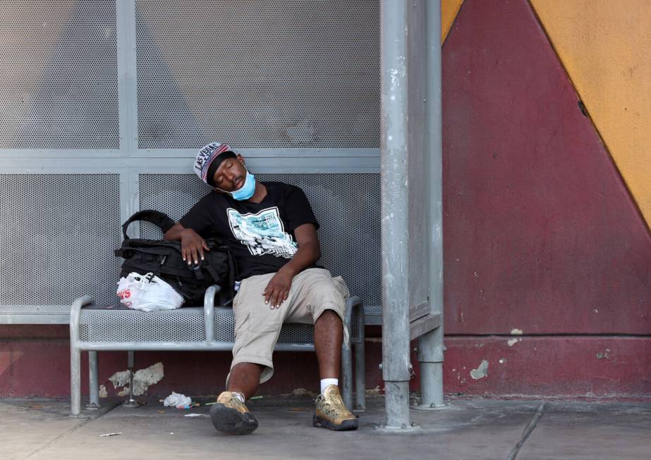 A person rests in the shade on Las Vegas Boulevard near Fremont Street on Aug. 17, 2020. (K.M. ...