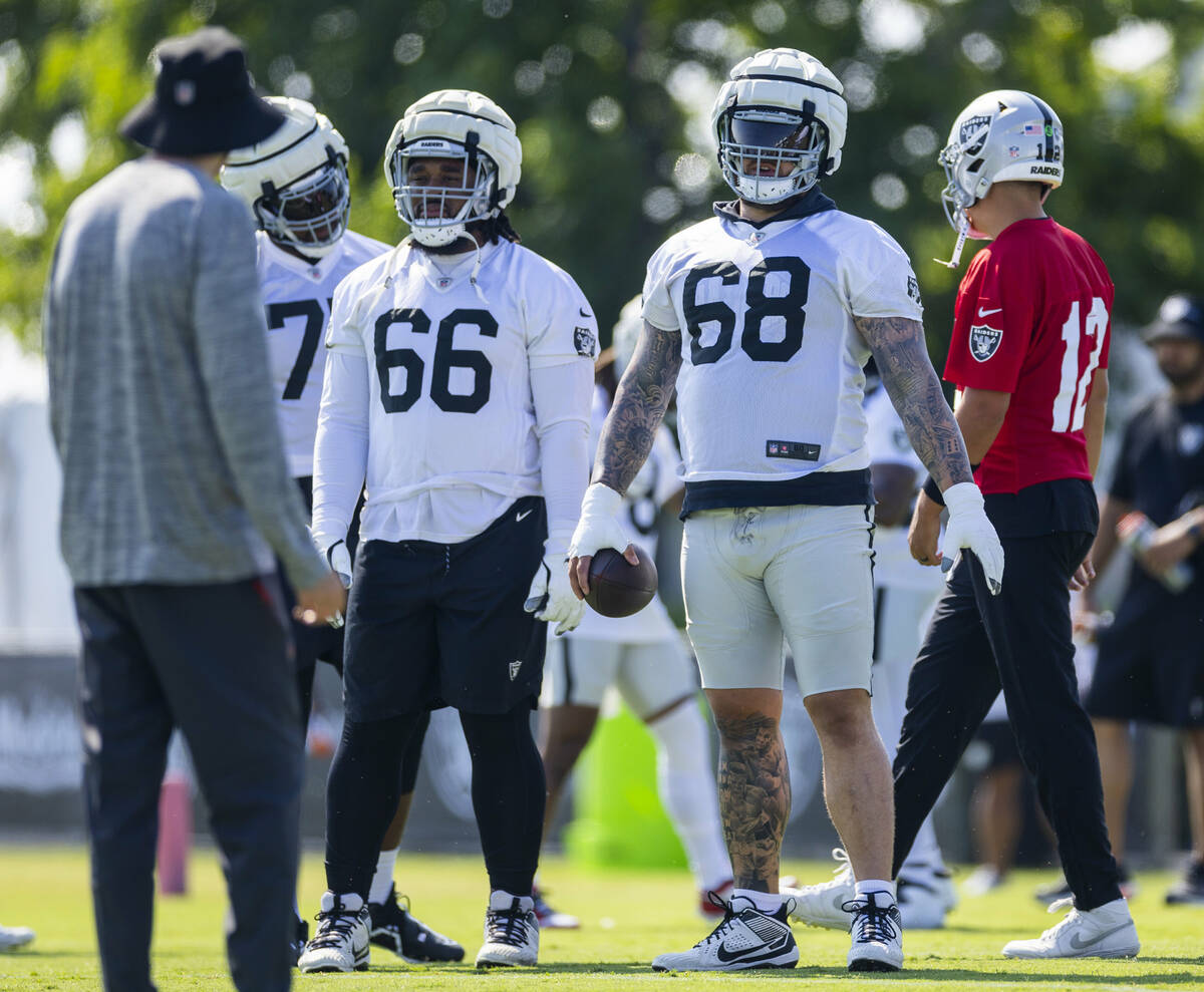 Raiders center Andre James (68) and guard Dylan Parham (66) listen to a coach during the second ...